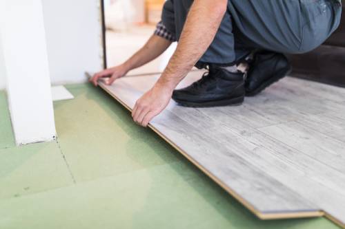 worker-processing-floor-with-laminated-flooring-boards (1)